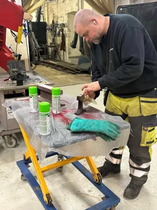 Fagperson undersøker et prøveemne på arbeidsbenken