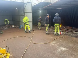 Kursgruppe på uteområdet mellom treningsbåser og utstyr